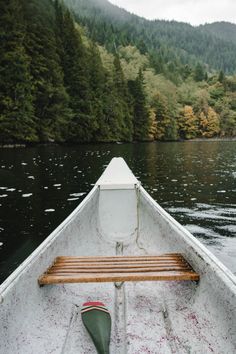 an empty boat on a lake with trees in the background