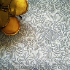 an overhead view of some decorative items on a blue and white tablecloth with gold accents