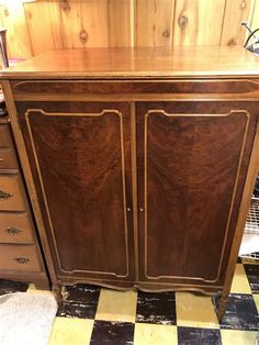 a wooden cabinet sitting on top of a checkered floor