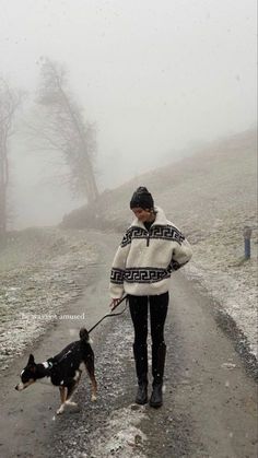 a woman walking her dog on a foggy day