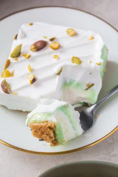 a piece of cake sitting on top of a white plate next to a fork and bowl