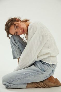 a woman sitting on the ground with her hands behind her head