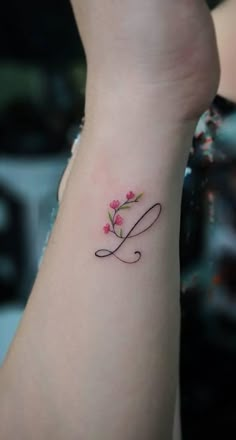 a woman's arm with a tattoo on it that has the letter l written in cursive writing