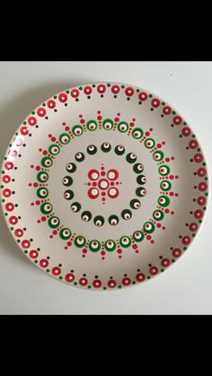 a white plate with red and green designs on it