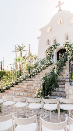 a set of white chairs sitting in front of a church