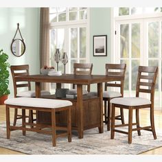 a dining room table with four chairs and a bench