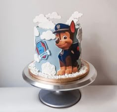 a birthday cake decorated with a cartoon dog and paw patrol on it's side