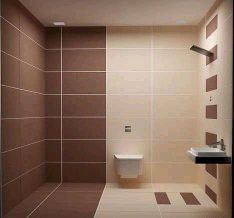 a bathroom with brown and white tiles on the walls