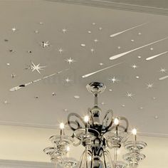 a chandelier hanging from the ceiling in a room with white walls and stars