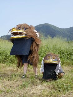 a person in a costume with an animal mask on their head standing next to a stuffed animal