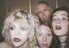 four people are posing for the camera with their mouths open