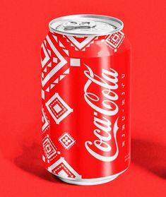 a can of coca - cola on a red background