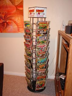 there is a tall tower made out of comic books on the floor next to a painting