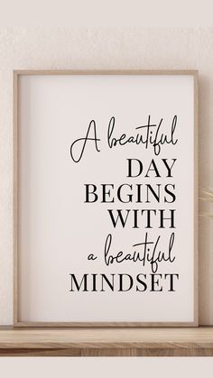 a beautiful day begins with a beautiful mindset print on a shelf next to a potted plant