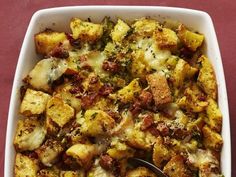 a casserole dish with potatoes and meat in it on a red tablecloth