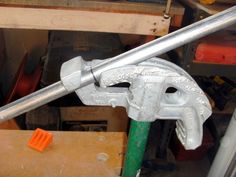 a close up of a wrench on a piece of wood with other tools in the background