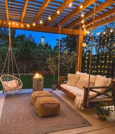 an outdoor living area with swing chairs and lights