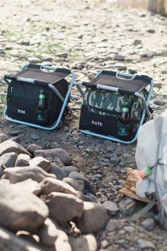 two coolers sitting on the ground next to rocks