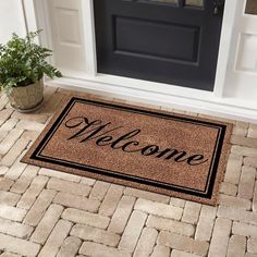 a welcome mat with the word welcome on it next to a potted plant in front of a door