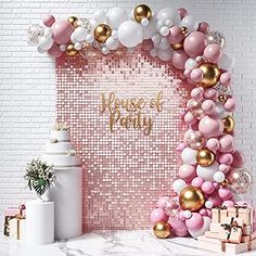 a pink and gold party backdrop with balloons