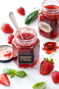 strawberry basil jam in a glass jar with spoons and fresh strawberries around it