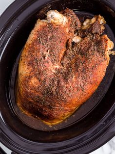 a close up of a cooked chicken in a crock pot with seasoning on it