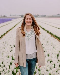 a woman standing in a field full of flowers