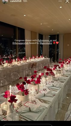 a long table is set with white linens and red flowers in clear vases