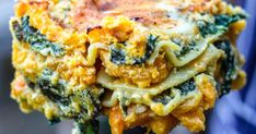 a close up of a person holding a plate of food with broccoli and cheese on it