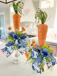 two carrots decorated with blue and orange flowers on a kitchen counter in front of an oven