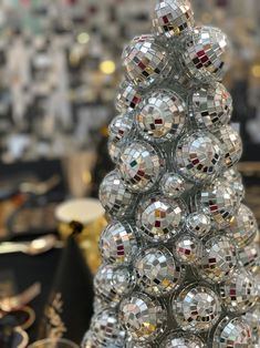 a christmas tree made out of disco balls in front of other items on the table