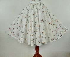 On a white cotton background, this wonderful novelty cotton summer circle skirt is chock full of black buzzing bees pollinating tomato red mid century stylized flowers. The waist buttoned is 24 1/2 inches, It closes in back with a metal zipper and carved shell button. It is not lined. LABEL: none CONDITION: very good plus presents beautifullyage and wear have resulted in very mild fading of fabric. When purchased, the skirt had what looked like coffee stains on front lower half , which improved White Cotton Skirt For Garden Party, Vintage White Gathered Skirt, White Vintage Gathered Skirt, White Vintage Skirt With Gathered Detail, Retro White Skirt For Summer, Retro Cotton Summer Skirt, White Retro Cotton Skirt, Retro White Full Skirt, White Retro Full Skirt