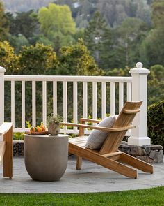 a wooden chair sitting on top of a patio next to a potted planter