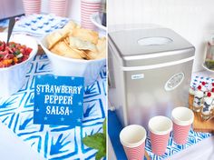 a table topped with cups and food next to a cooler