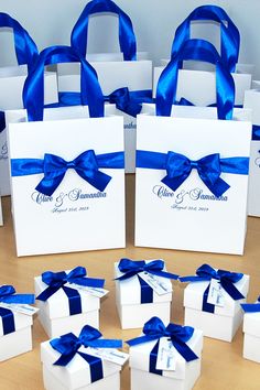 many white boxes with blue ribbons and bows