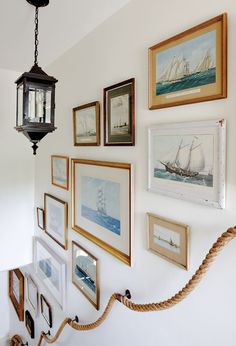 there are many framed pictures on the wall with rope hanging from it's side