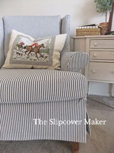 a blue and white striped chair with a horse pillow on it's back in front of a dresser