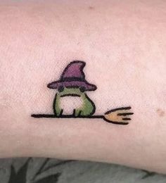 a person with a small tattoo on their arm holding a fork and wearing a purple hat