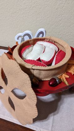 a table topped with a red plate filled with food and paper masks on top of it