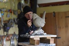 a man working on a sculpture in a shop