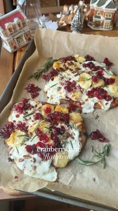 pizza with cranberry sauce and pineapple toppings on parchment paper, ready to go into the oven