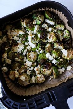 brussel sprouts with feta cheese and olives in a roasting pan