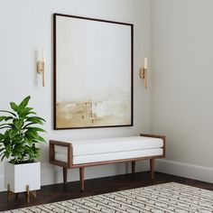 a white couch sitting next to a potted plant