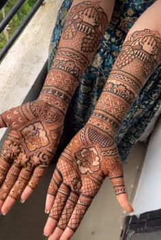 two hands with henna tattoos on them