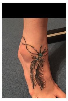 a person's foot with a tattoo on it and a feather in the middle