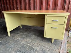 an old yellow desk with two drawers