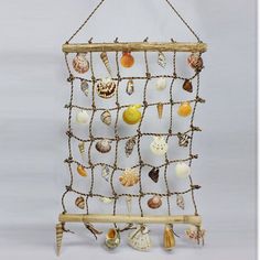 a wooden frame with seashells hanging from it's sides on a rope