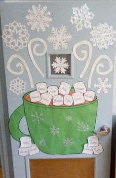 a door decorated with snowflakes and a green cup filled with marshmallows