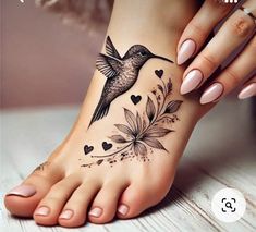 a woman's foot with a bird and flowers tattoo on the bottom of it