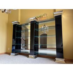 an empty room with glass shelves and chandelier